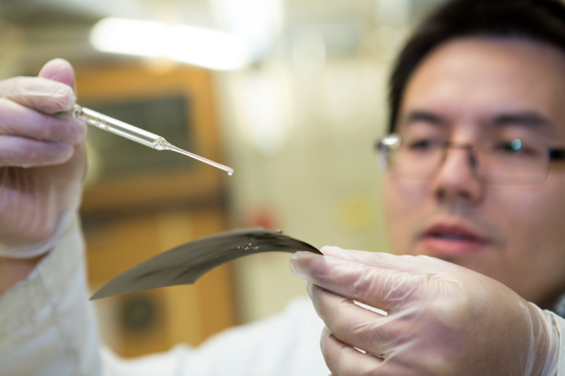 Man dripping substance on paper