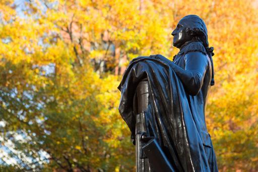 George Statue in University Yard with yellow fall leaves in the background